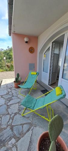 um pátio com 2 cadeiras, uma mesa e um cacto em La Civetta - Relax tra verde e mare a 10 minuti da Sestri Levante em Casarza Ligure
