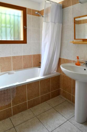une salle de bain avec une baignoire et un lavabo dans l'établissement Villa CASA CALLISTA , confort et calme, à Sainte-Lucie de Porto-Vecchio