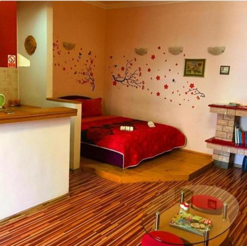 a bedroom with a bed with red sheets and flowers on the wall at 2A Apartments Bascarsija in Sarajevo