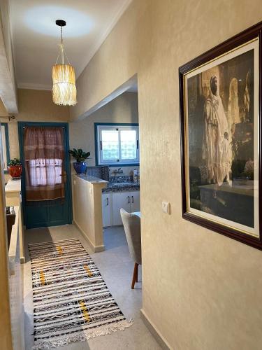 Una sala de estar con un cuadro en la pared y una cocina. en Sweet home, en Oualidia