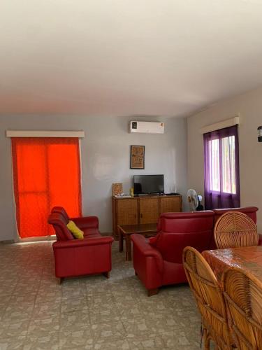 a living room with red chairs and a red couch at Villa duchesse in Sali Nianiaral