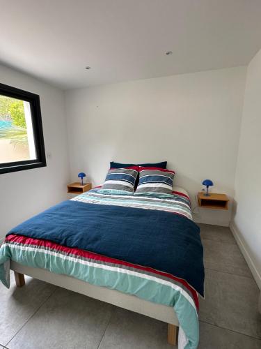 une chambre avec un lit avec des draps bleus et une fenêtre dans l'établissement Appartement T2 Casa Di Simone Pietrosella Corse du Sud, à Pietrosella