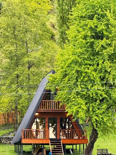 a cabin in the woods with a black roof at Phaliani's Heaven in Mestia