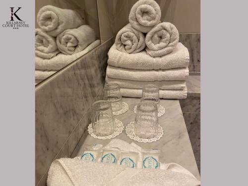 eine Badezimmertheke mit Handtüchern und einem Haufen Handtücher in der Unterkunft Killarney Court Hotel in Killarney