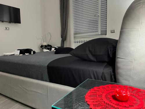 Un dormitorio con una cama y una mesa con una flor roja. en holiday home Un posto solare, en Nápoles
