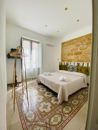 a bedroom with a bed and a brick wall at Donna Carmela in Porticello