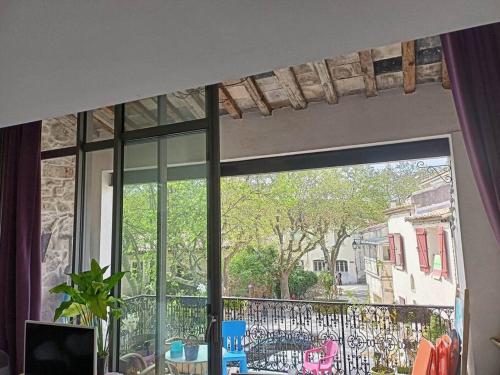 une fenêtre avec vue sur un balcon dans l'établissement Jolie maison de village, à Grabels