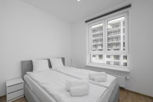 ワルシャワにあるŻeńców 5 by NYX Apartの白いベッドルーム(大型ベッド1台、窓付)