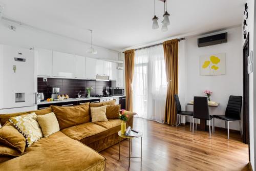 a living room with a couch and a kitchen at ARI Yellow Apartment - Panoramic View in Arad