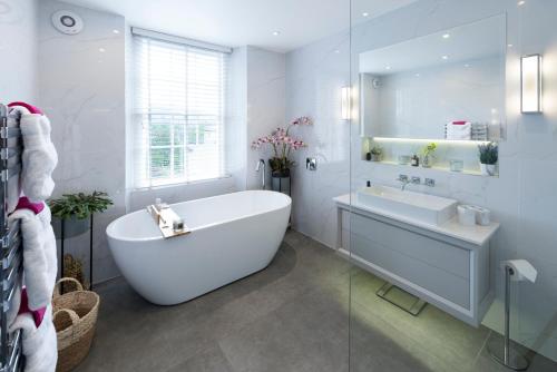 a white bathroom with a tub and a sink at The Old Wine Merchant's House in Bath