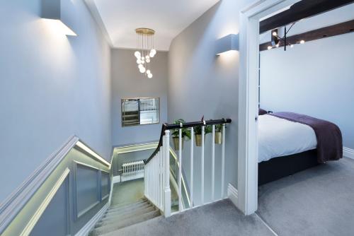 a bedroom with blue walls and a bed and a staircase at The Old Wine Merchant's House in Bath