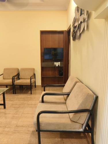 a waiting room with two chairs and a tv at Shraddha hospitality in Calangute