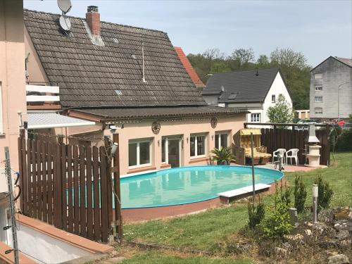 a house with a swimming pool in the yard at Ferienhaus Gerhard in Hornbach