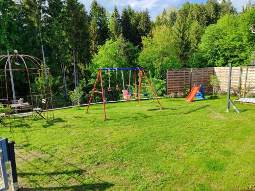 a playground with two swings in a yard at Sigi Apartment in Barnbach