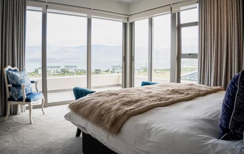 a bedroom with a bed and a large window at Milk and Honey Villa 192 in Hermanus