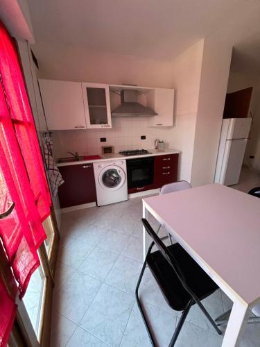 a kitchen with a table and a washing machine at Sesta Terra in Aulla