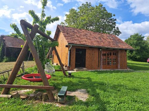 a log cabin with a playground in front of it at Kokotova hiža in Gornja Konjšćina