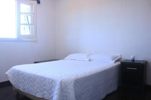 a bedroom with a white bed with a window at Playa Grande Dos Ambientes in Mar del Plata