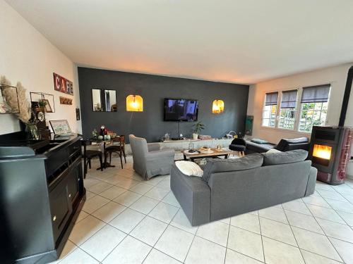 a living room with couches and a dining room at Gîte Cosy Green in Chevincourt