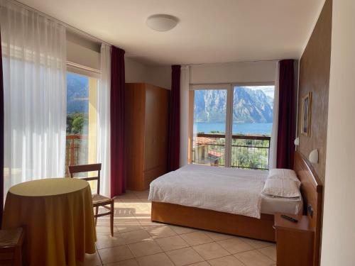 ein Schlafzimmer mit einem Bett und einem großen Fenster in der Unterkunft Hotel Casa Chincarini in Malcesine