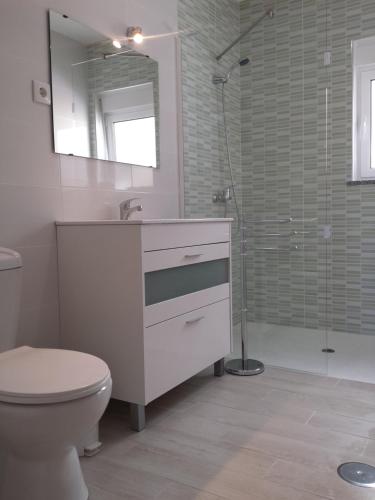 uma casa de banho com um lavatório, um WC e um chuveiro em Casinha do Mar em Carvide