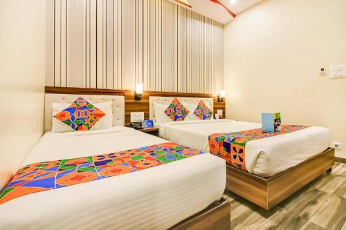 a bedroom with two beds with colorful sheets at New Axis International By Glitz Hotels in Mumbai