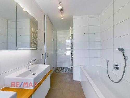 a white bathroom with a sink and a shower at Kaiserstrand Apartment Bodensee - Lake Constance, Lochau - Bregenz, Austria in Lochau