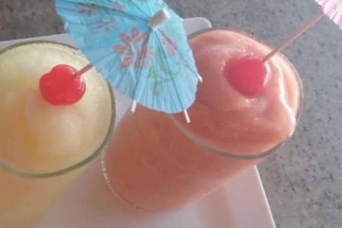 two drinks with umbrellas on top of them on a plate at Gated Riverside Studio Apartment in San Juan