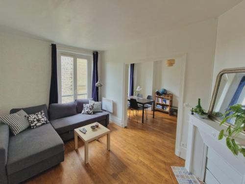 un salon avec un canapé et une table dans l'établissement Beautiful, cosy apartment for 1 to 6 people, located near Olympic Park, à Paris