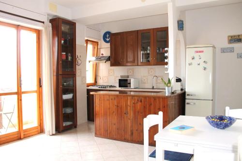 uma cozinha com armários de madeira e um frigorífico em Casa Serendipity Sabaudia em Sabaudia