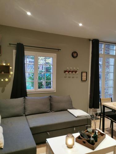 a living room with a couch and a table at gîte Cosy Green 2 in Chevincourt