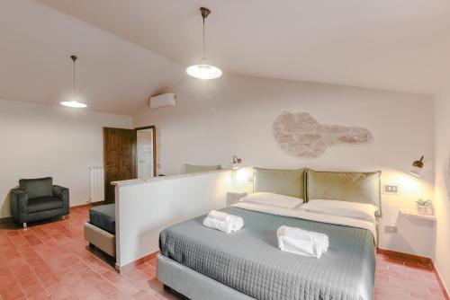a bedroom with a bed and a chair at Agriturismo Il Mulino delle canutole in Magione