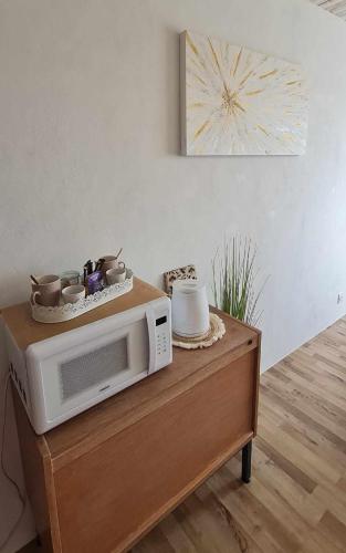 Un four micro-ondes est installé au-dessus d'une table en bois. dans l'établissement Le Cocon de Mina, 15 min du Puy du Fou, à Mortagne-sur-Sèvre