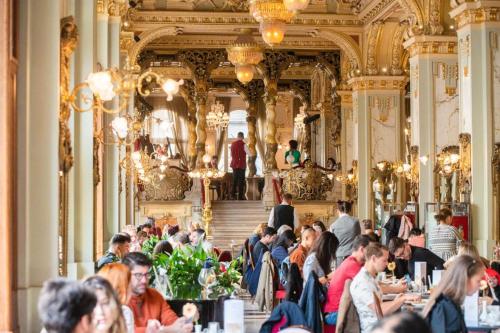 un gruppo di persone seduti ai tavoli in un ristorante di Saffron Apartment-Panoramic Balcony a Budapest