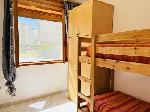 Ce lit superposé se trouve dans un dortoir doté d'une fenêtre. dans l'établissement Condominio GIULIANA, à Bibione