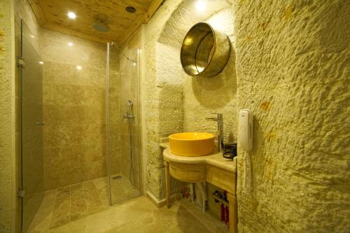 a bathroom with a yellow sink and a shower at Panoramic Cave Hotel in Goreme