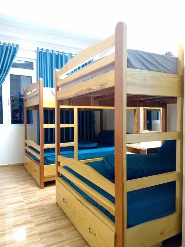 two bunk beds in a room with blue beds at Anh Đào Dalat House in Da Lat
