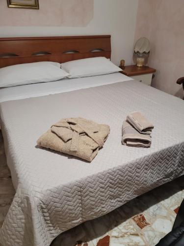 ein weißes Bett mit zwei Handtüchern darüber in der Unterkunft Italias House in Ciampino