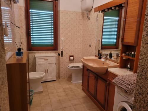 ein Badezimmer mit einem Waschbecken, einem WC und einem Waschbecken in der Unterkunft Italias House in Ciampino