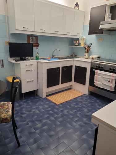 eine Küche mit weißen Schränken und blauem Boden in der Unterkunft Italias House in Ciampino