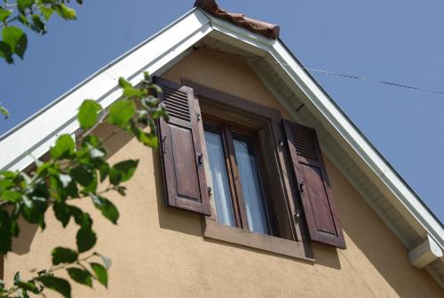 une fenêtre ouverte sur le côté d'une maison dans l'établissement La Maison de Vacances de Colmar et son jardin, à Colmar