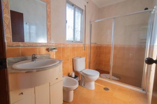 uma casa de banho com um lavatório, um WC e um chuveiro em Vivienda Unifamiliar 500 m cuadrados na Isla Cristina