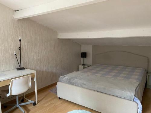 un lit dans une chambre avec un bureau et un lit sidx sidx sidx dans l'établissement Grande chambre 25m - CLIM, à Castelnau-le-Lez