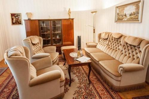 sala de estar con sofás, sillas y mesa en Haus in Budapest mit großem Garten für Familien und Hund en Budapest