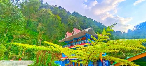 un edificio en medio de una montaña con árboles en Sikkim Silk Route Riverside Resort, Rongli, en Rongli