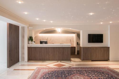 a lobby with a reception desk and a flat screen tv at Villa Nicolli Romantic Spa Resort - Adults Only in Riva del Garda