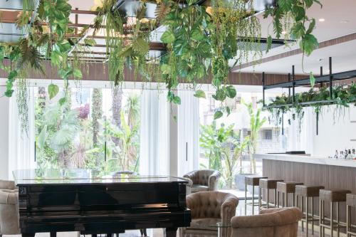 a room with a piano and chairs and plants at Villa Nicolli Romantic Spa Resort - Adults Only in Riva del Garda