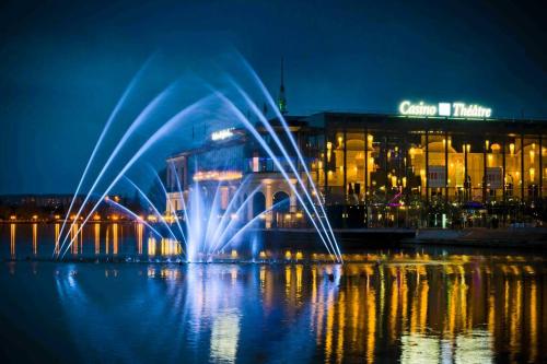 a fountain in the water in front of a building at Appartement rénové et spacieux, Terrasse, 4 pers in Franconville