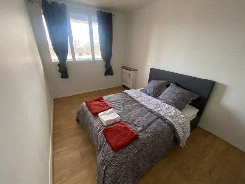 a bedroom with a large bed with two pillows at Appartement rénové et spacieux, Terrasse, 4 pers in Franconville