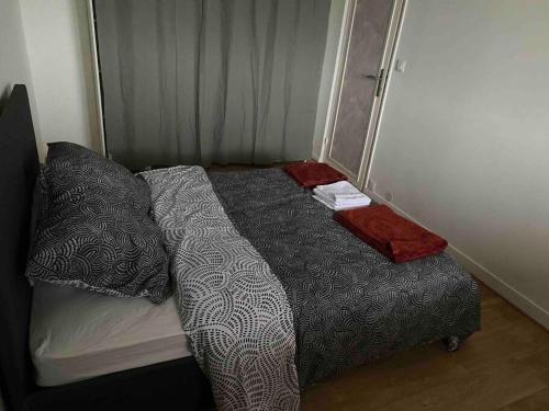 a bed in a small room with at Appartement rénové et spacieux, Terrasse, 4 pers in Franconville